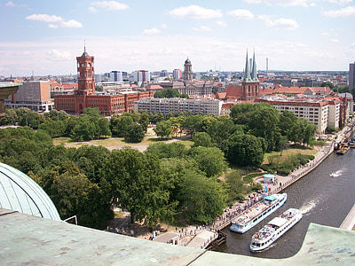 ferries maneuvers on canal near city buildings thumbnail