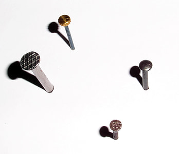 four gray nails on white surface thumbnail