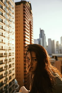 selective focus photography of black haired woman front of building thumbnail