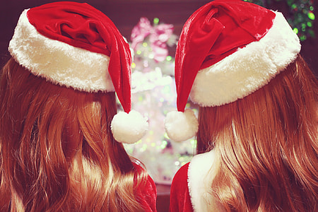 two woman wearing santa hats thumbnail