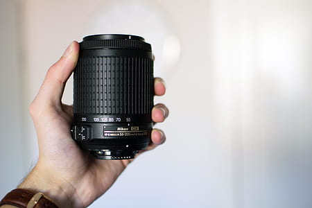 person holding DSLR camera lens thumbnail