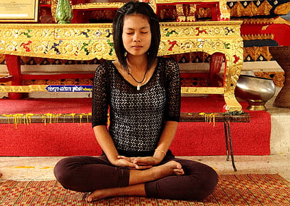 woman sits on rug beside table thumbnail