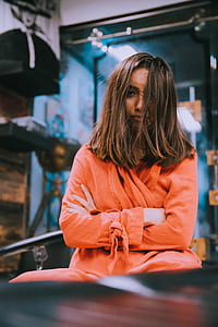 woman sitting wearing orange robe inside room thumbnail