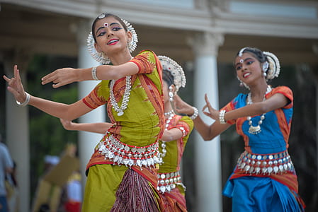three women performing traditional dance near white concrete posts thumbnail