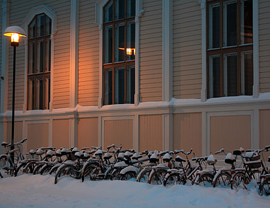 Snowy bicycles in front of library of architecture of Oulu University in Finland thumbnail