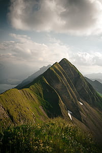 photo of green hill under grey cloudy sky thumbnail