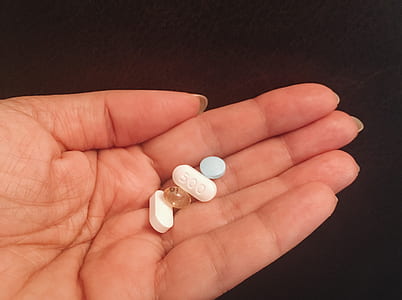 five medication pills on person's palm thumbnail