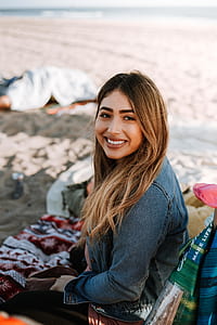 smiling and sitting woman on seashore thumbnail