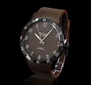 photo of round black analog watch with brown leather strap thumbnail