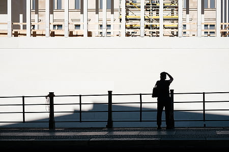silhouette of person standing beside white wall thumbnail