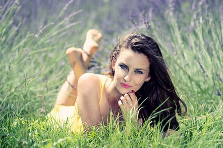woman wearing yellow sleeveless dress laying on green grass thumbnail