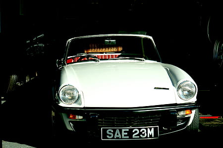 white Porsche 911 parked in machine shop thumbnail