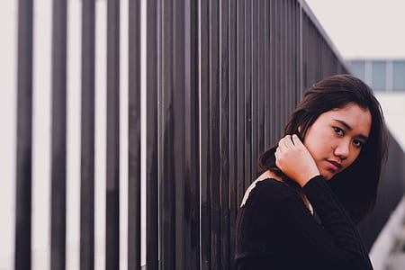 woman holding her neck leaning on fence thumbnail