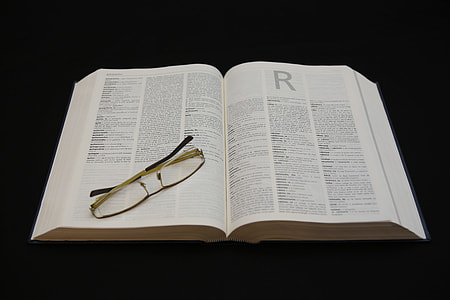 yellow framed eyeglasses on top of opened book thumbnail