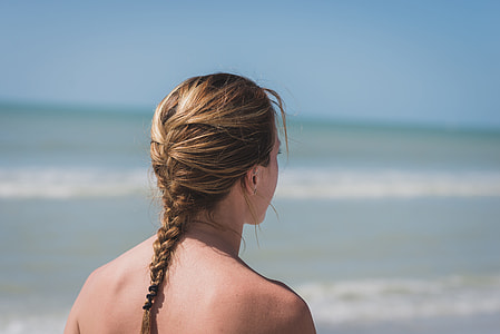 selective focus photography of woman with braided hair standing near beach during daytime thumbnail