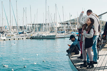 People Standing on Dock Fishing Near Boat Port thumbnail