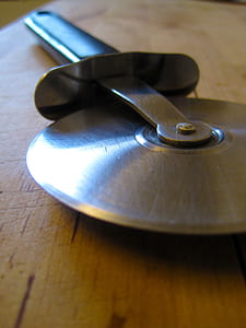 gray pizza slicer on brown surface thumbnail