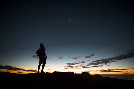 silhouette photography of man standing on peak thumbnail