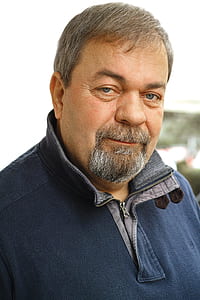 smiling man in blue sweater thumbnail