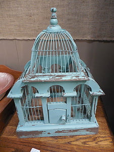 blue steel birdcage on brown table thumbnail