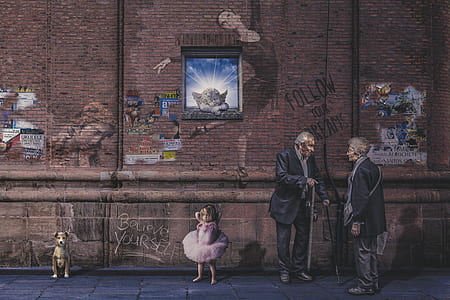 two men standing next to girl and sitting dog on pavement painting thumbnail