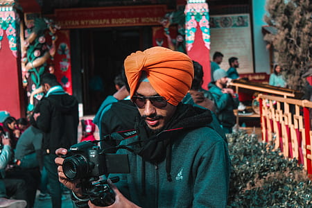 man holding Canon DSLR camera during daytime thumbnail