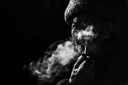 grayscale photography of man smoking pipe thumbnail