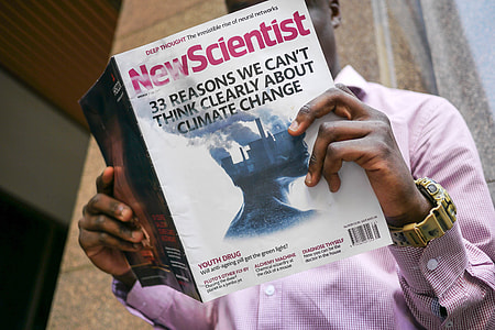 man holding New Scientist magazine thumbnail