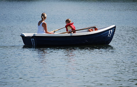 woman and girl riding boat on body of water thumbnail