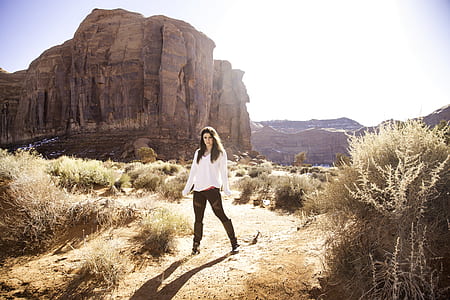 woman wearing white dress shirt standing near brown cliff thumbnail