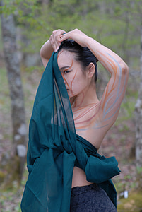 woman covering face with green textile thumbnail