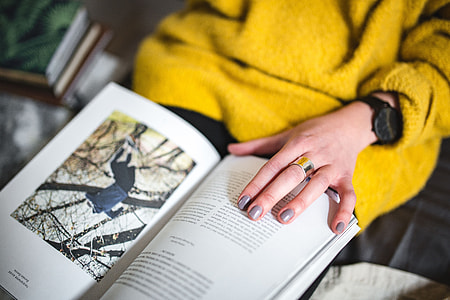 Young woman reading a magazine in bed thumbnail