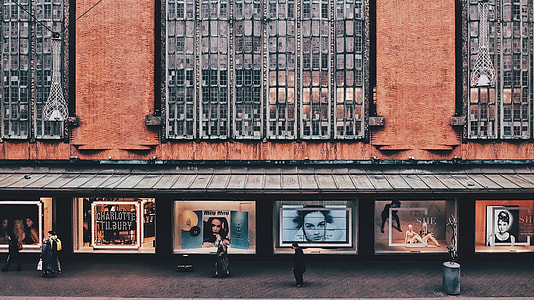 people standing near on brown brick building during daytime thumbnail