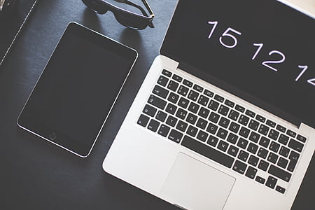 silver MacBook beside black iPad thumbnail