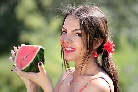 smiling woman holding slice of watermelon thumbnail