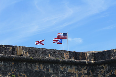 three country flags near brown building thumbnail