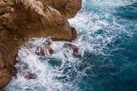 water waves on brown rock cliff thumbnail