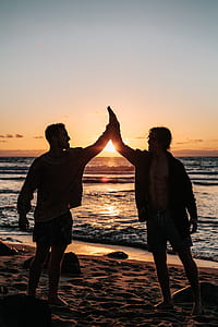 two men doing high five on beach thumbnail