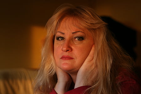 close-up photography of woman holding her ears near well-lit room thumbnail