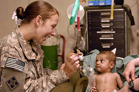 baby with dextrose sitting on sofa near woman wearing soldier uniform thumbnail