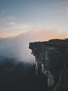 brown cliff under white cloudy sky thumbnail