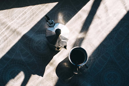 gray stainless steel cup beside moka pot on top of table thumbnail