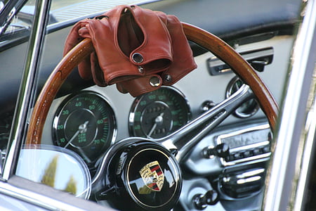 brown jacket on black Porsche steering wheel thumbnail
