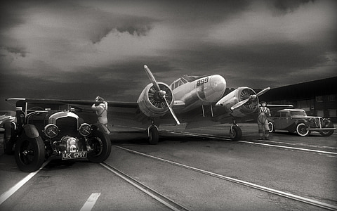 grayscale photo of airplane and cars thumbnail