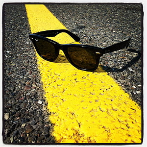 Ray-Ban sunglasses on yellow road line thumbnail