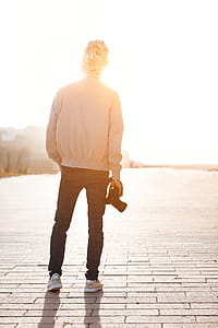 Boy Standing While Holding Camera Overlooking Sunlight at Daytime thumbnail