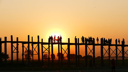 silhouette of people on wooden dock during sunset thumbnail