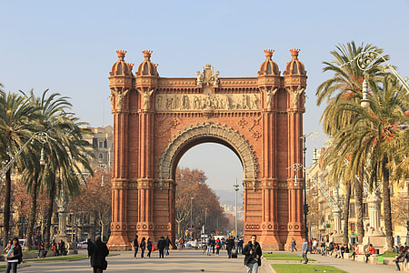 people passing under Arch De Triumph under blue skies thumbnail