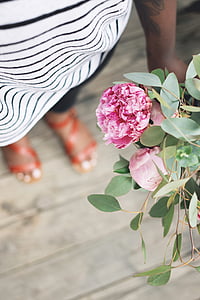 person holding pink flowers thumbnail