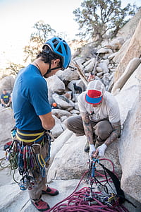 man in blue shirt and helmet standing on gray stone during daytime thumbnail